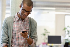 Man in office looking at phone